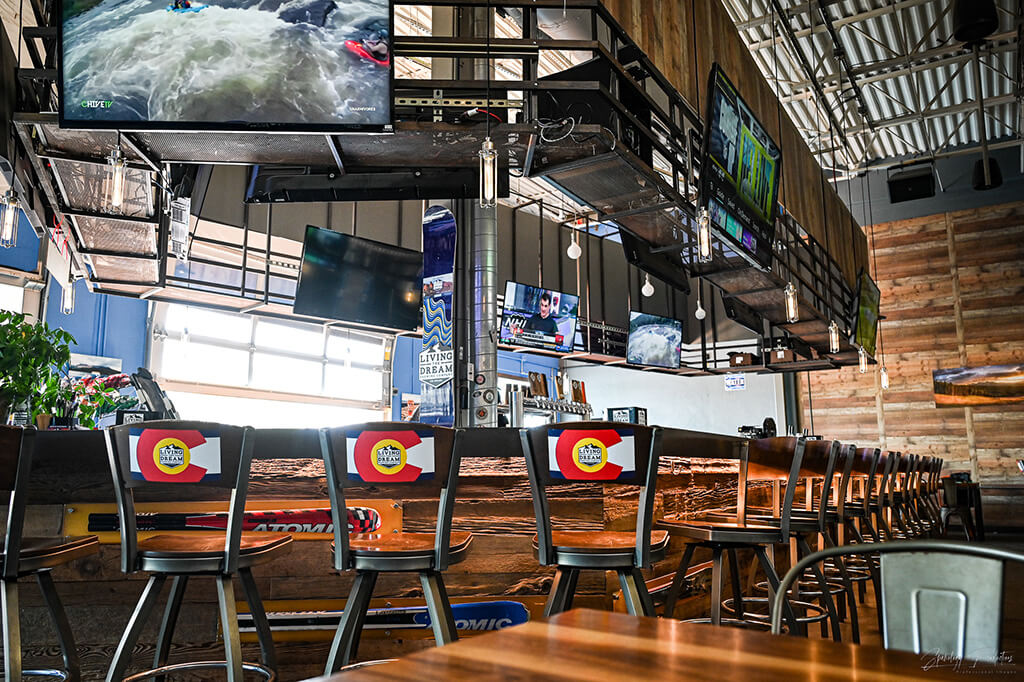 interior of Highlands Ranch location with numerous televisions overhead and ample barstool seating